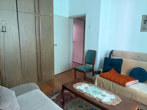 Dnevna soba sa garniturom, drvenim ormarom i stolom. - image 2