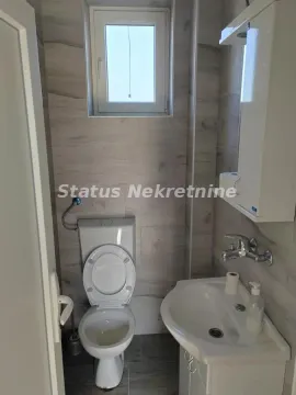 Smaller bathroom with a toilet, sink, and window. - image 15