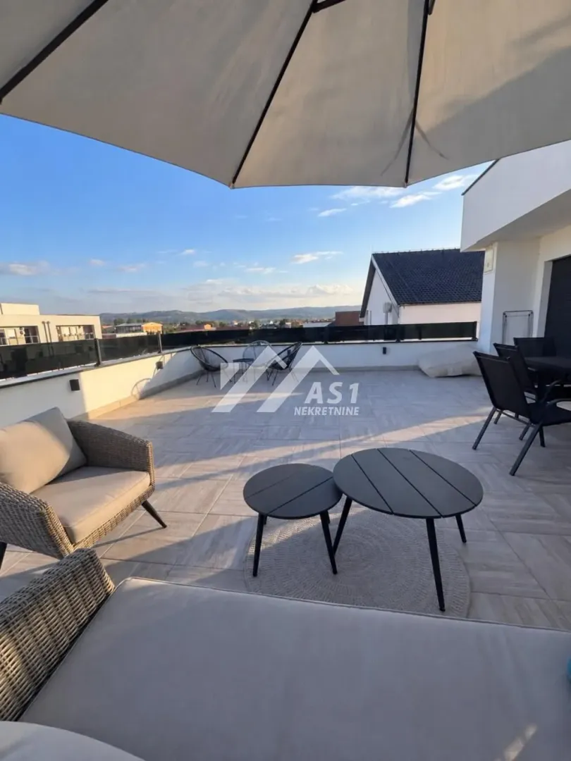 Spacious rooftop terrace with outdoor seating and surrounding views.