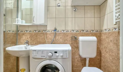 Kupatilo opremljeno umivaonikom, WC šoljom, tuš kabinom i veš mašinom. - image 9