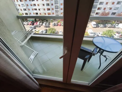 View of a tiled balcony with a table, chairs, and a clothes drying rack. - image 14
