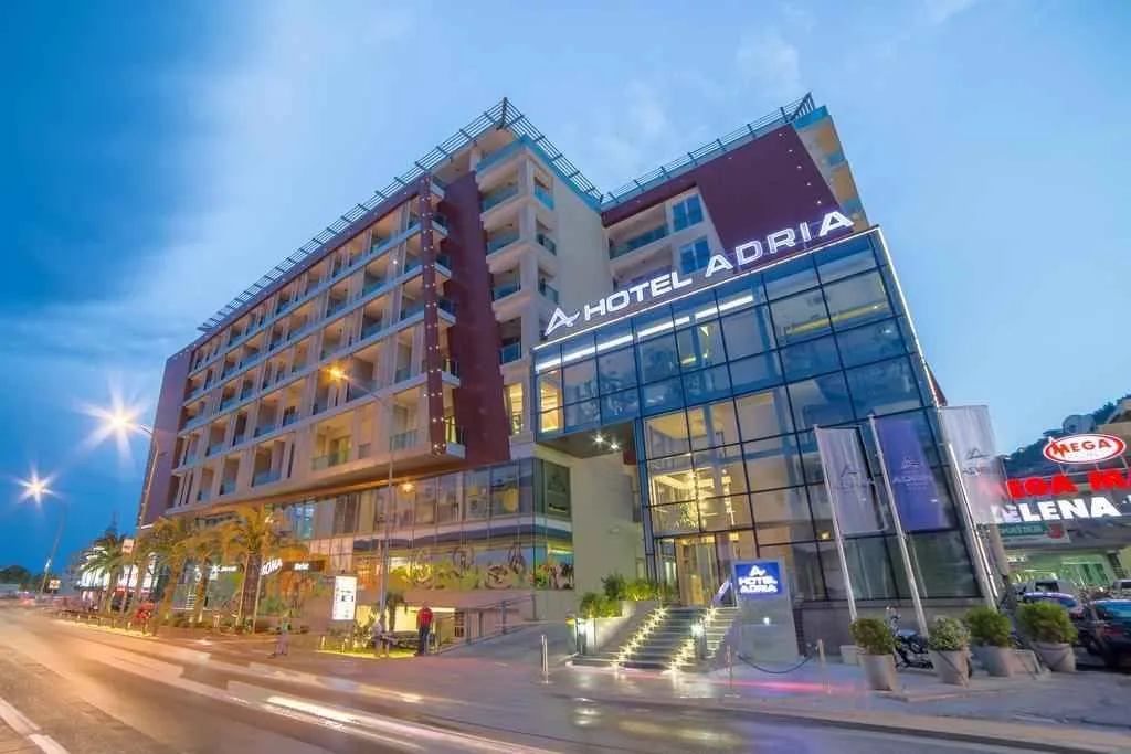 Exterior view of a modern hotel building with lighting at dusk.