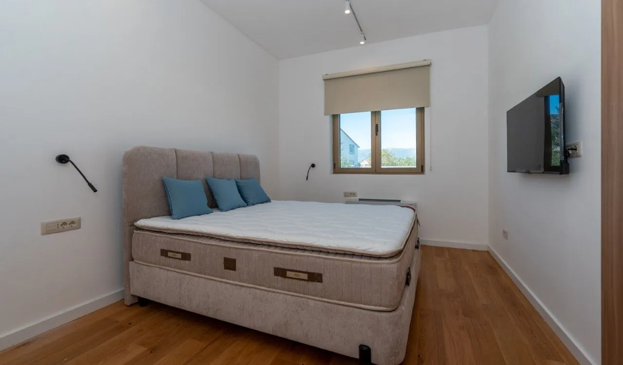 Bedroom with a double bed and a wall-mounted TV.