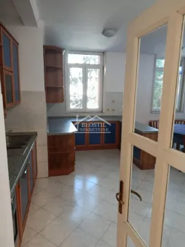 View of the kitchen with wooden cabinets through an open door. - image 11