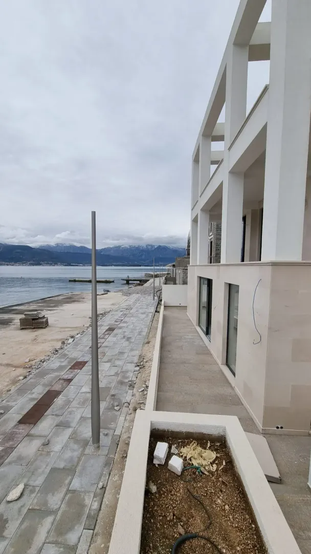 Eksterijer zgrade u izgradnji pored mora sa šetalištem.