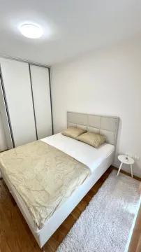 Spavaća soba sa bračnim krevetom, bijelim garderoberom i malim noćnim stočićem. - image 6