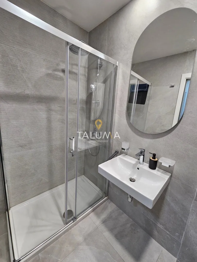 Modernly equipped bathroom with a walk-in shower and washbasin.