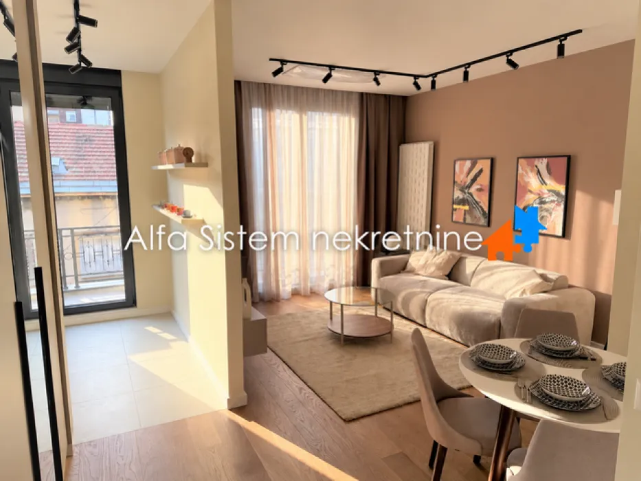 Living room with a sofa, dining table, and access to the terrace.
