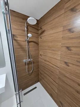 Tuš kabina sa zidnim pločicama u imitaciji drveta i staklenom pregradom. - image 12