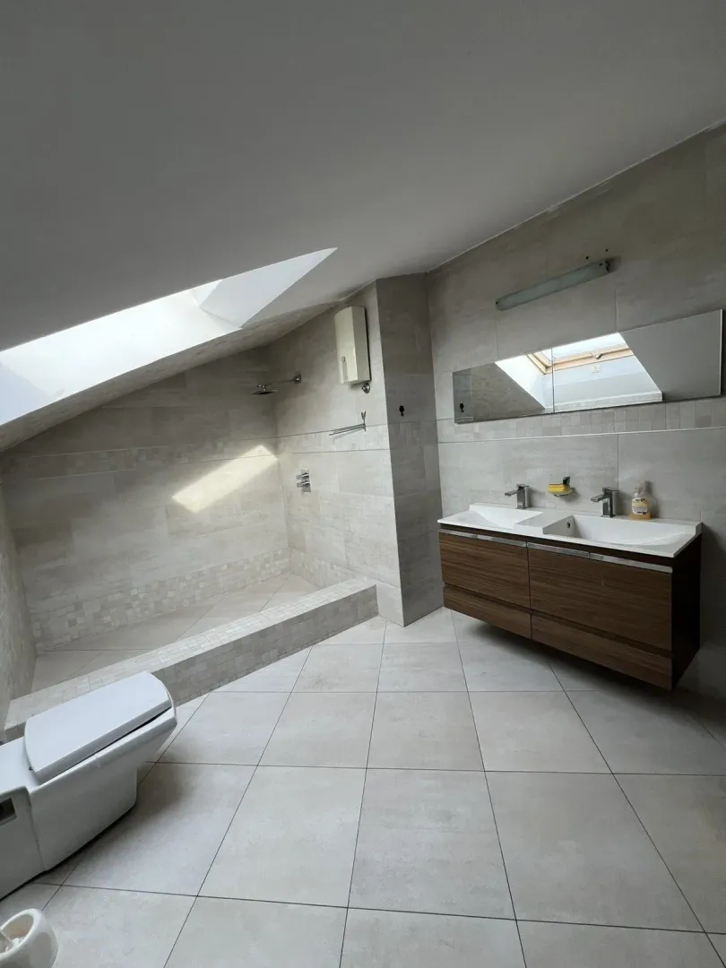 Attic bathroom with a shower and double vanity.