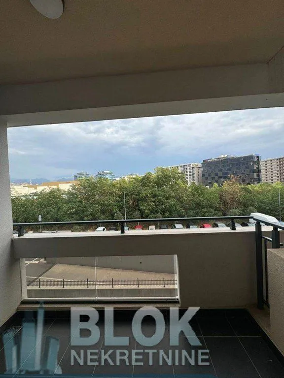 Covered terrace with a view of surrounding buildings and greenery.