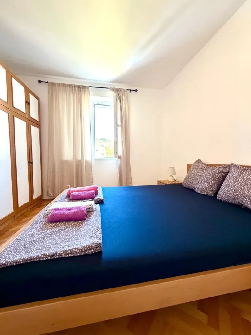 Bedroom with a double bed, wardrobe, and a window.