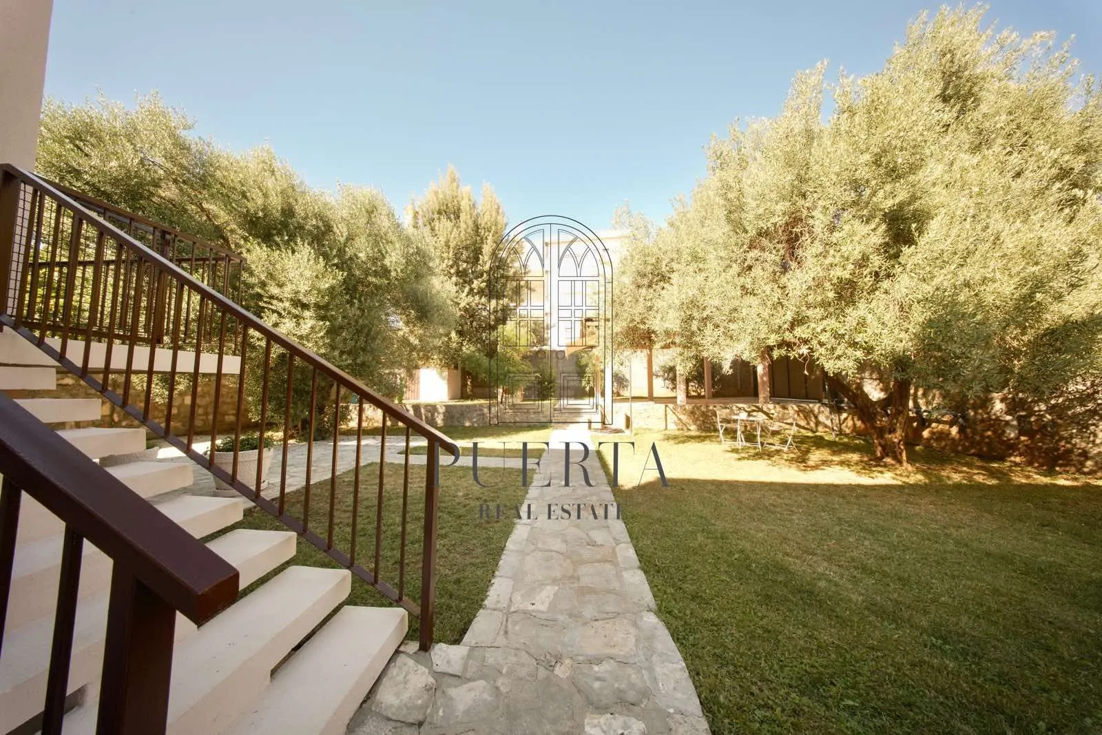 Property exterior with a paved pathway, stairs, and landscaped yard.