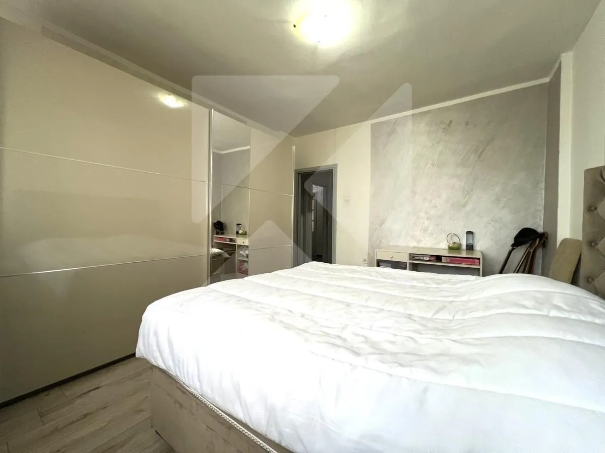 Bedroom with a large double bed and a fitted wardrobe.