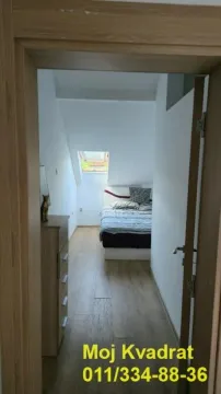 Pogled iz hodnika na spavaću sobu sa krevetom i krovnim prozorom. - image 10
