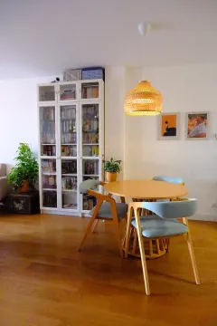 Dining table with chairs and a white bookcase in the living room. - image 6