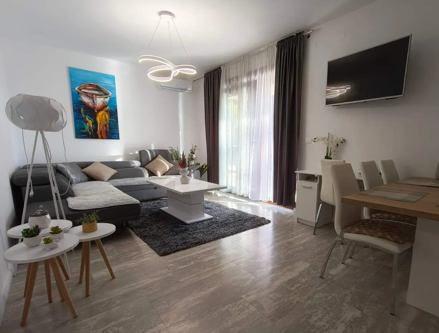Modern living room with a sofa set, dining area, and access to the terrace.