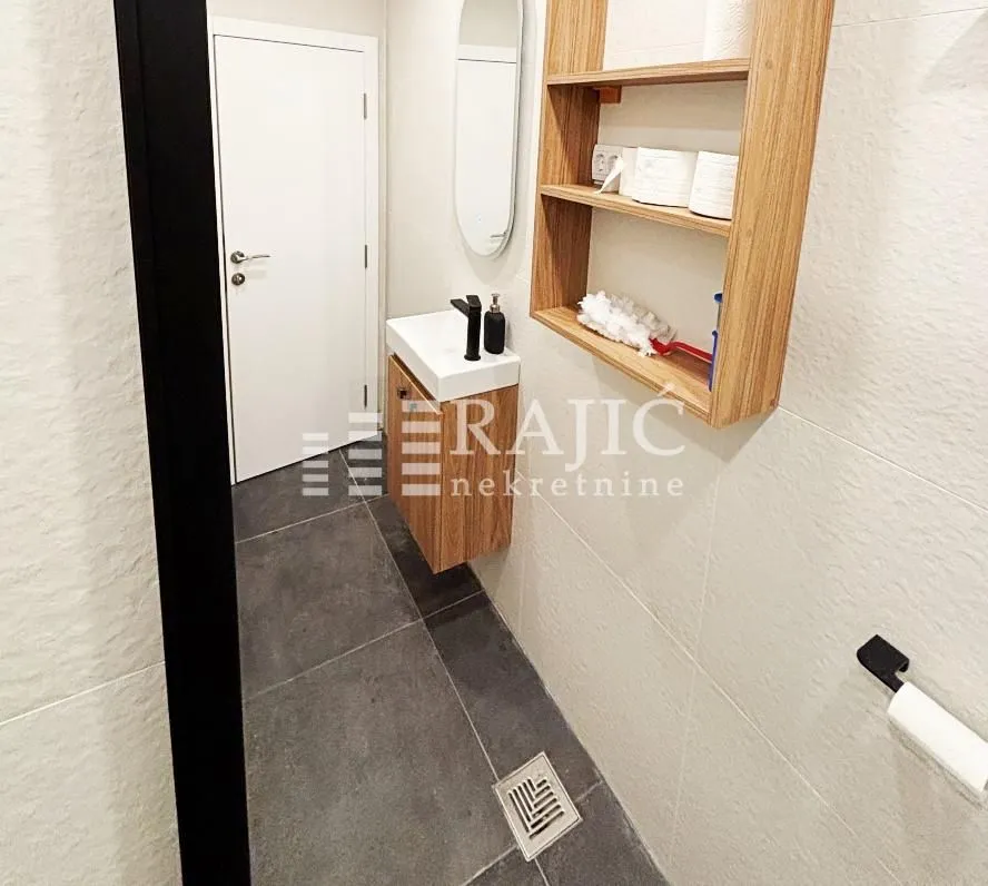 Smaller bathroom with a washbasin and wooden cabinet.