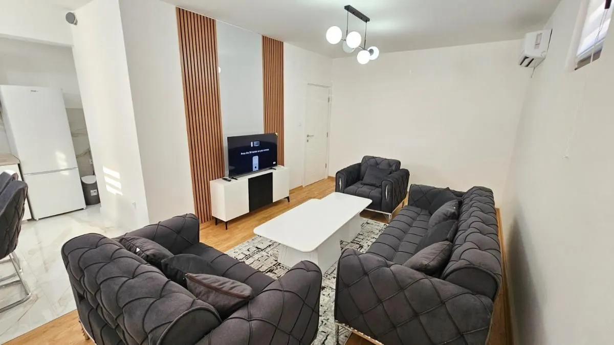 Moderna dnevna soba sa garniturom, stočićem i televizorom.