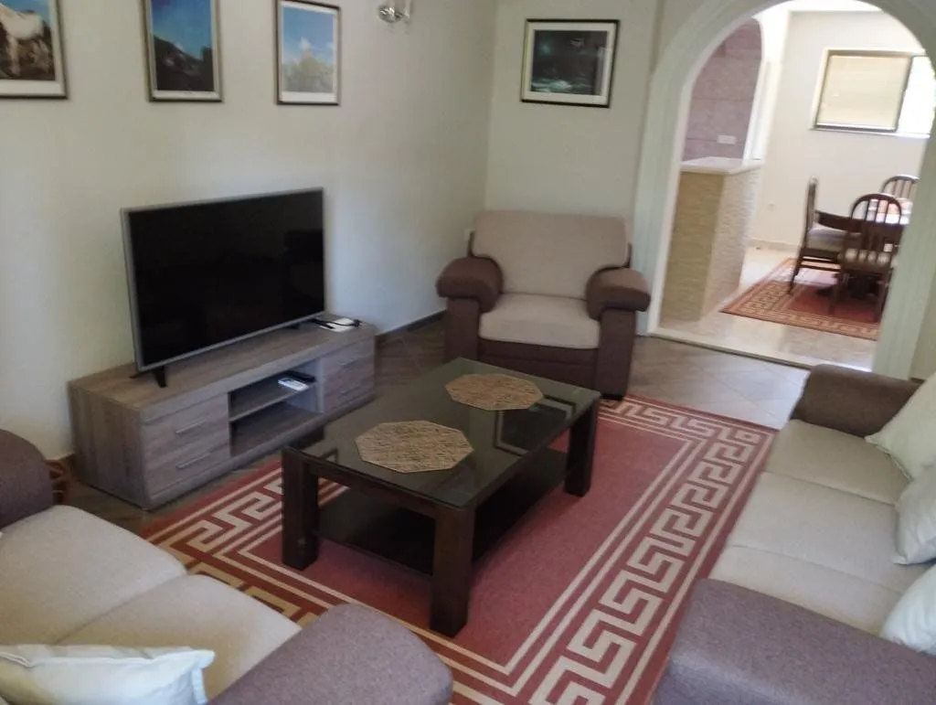 Living room with a sofa set, television, and a view of the dining area.