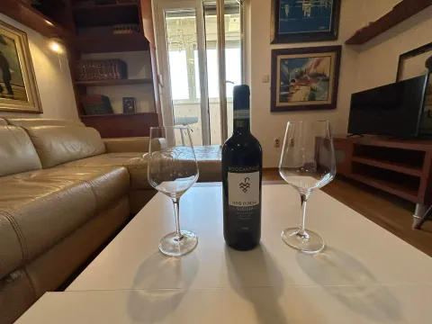 Living room with a sofa and a coffee table featuring a bottle of wine and glasses. - image 7