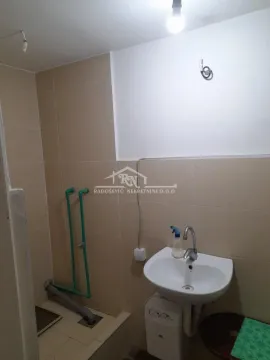 Small bathroom with a sink and wall tiles. - image 2