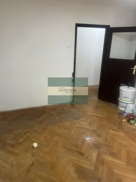 Prazna prostorija sa parketom i tamnim vratima. - image 2