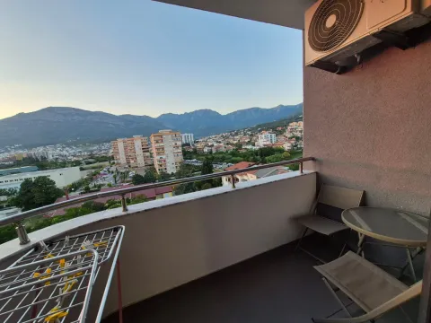 Namješten balkon sa garniturom za sjedenje i pogledom na grad i planine. - image 12