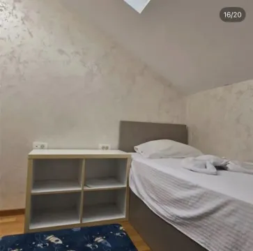 Small bedroom with a bed and a low shelving unit under the sloped ceiling. - image 5