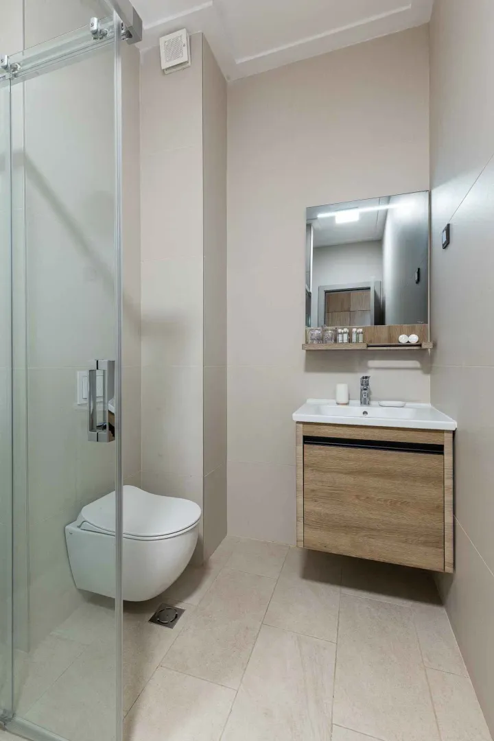 Savremeno opremljeno kupatilo sa tuš kabinom, umivaonikom i WC šoljom.