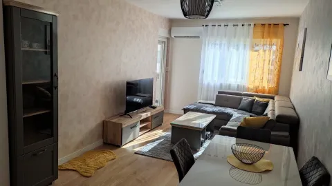 Living room with a sofa, TV, and dining table. - image 4