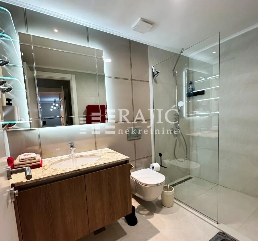 Modernly equipped bathroom with a walk-in shower and washbasin.