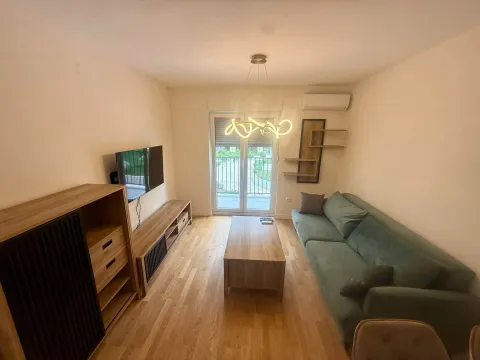 Living room with a sofa, TV, and coffee table. - image 3