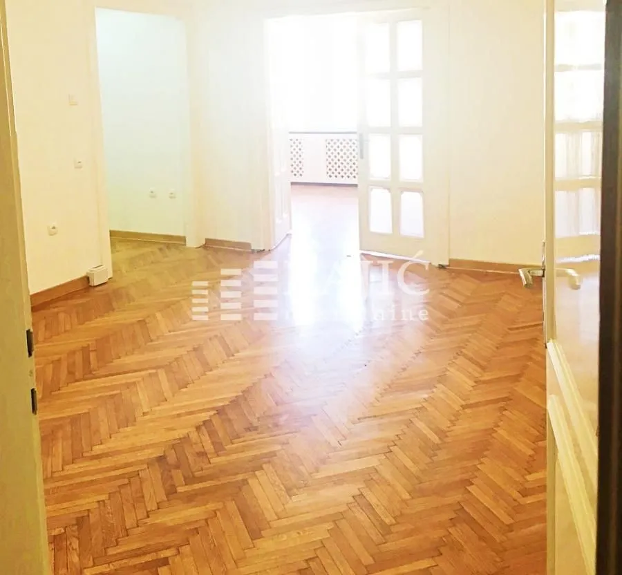 Empty room with parquet flooring and white interior doors.