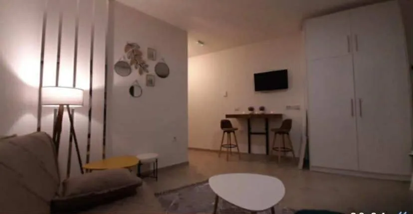 Living room with a sofa, coffee tables, and a wardrobe.