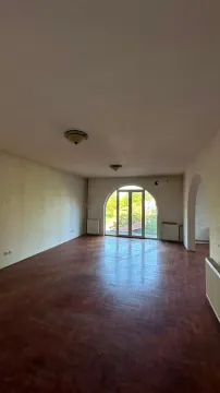 Empty room with wooden parquet flooring and arched balcony doors. - image 14