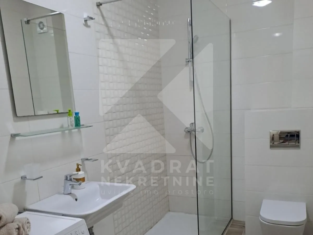 Moderne kupatilo sa tuš kabinom, umivaonikom i WC šoljom.