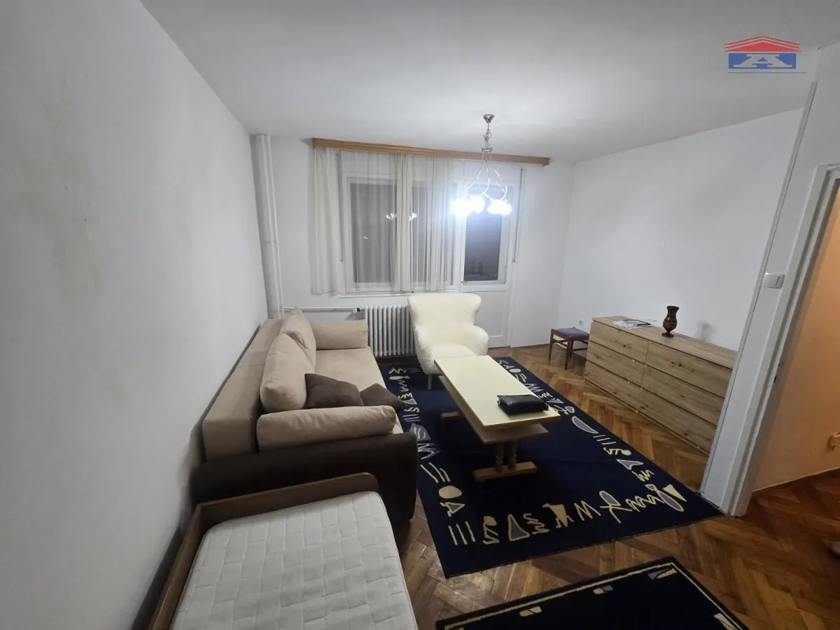 Dnevni boravak sa garniturom za sedenje, foteljom i komodom.