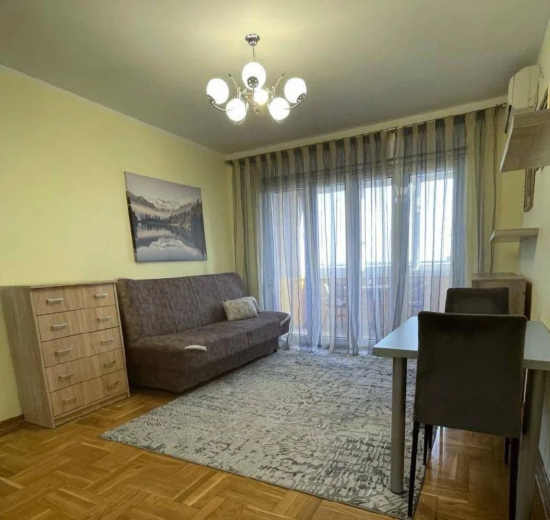Dnevni boravak sa garniturom, trpezarijskim stolom i izlazom na terasu.