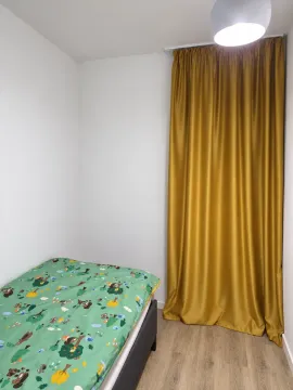 Manja spavaća soba sa krevetom i zlatnim zavjesama. - image 5
