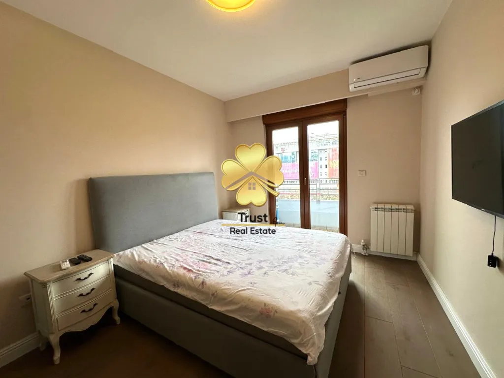 Furnished bedroom with a double bed, chest of drawers, and balcony access.