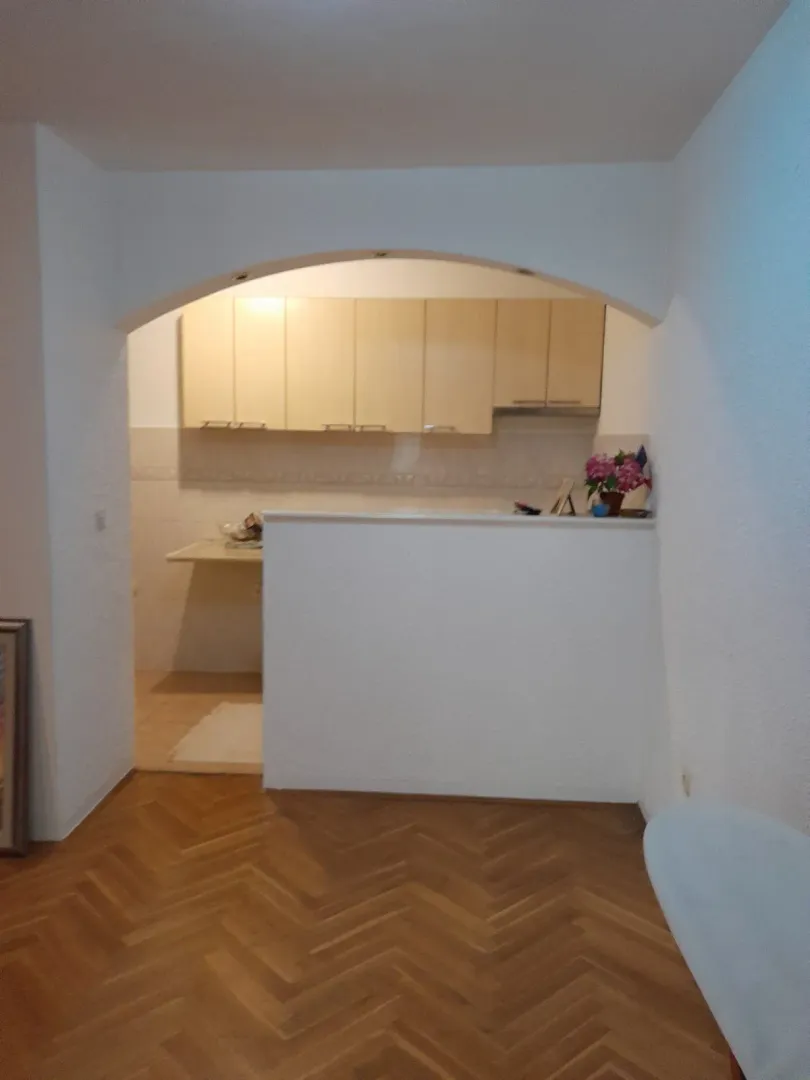 Pogled na kuhinju sa drvenim elementima kroz ukrasni luk.