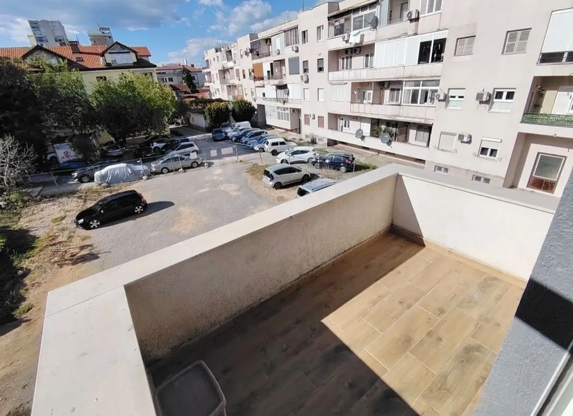 View from the balcony overlooking the parking lot and surrounding buildings.
