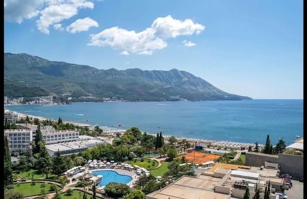 View from the window overlooking the sea, coast, and mountains in the background.