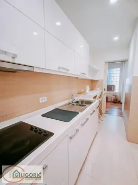 Modern white kitchen with built-in cooktop and sink. - image 14