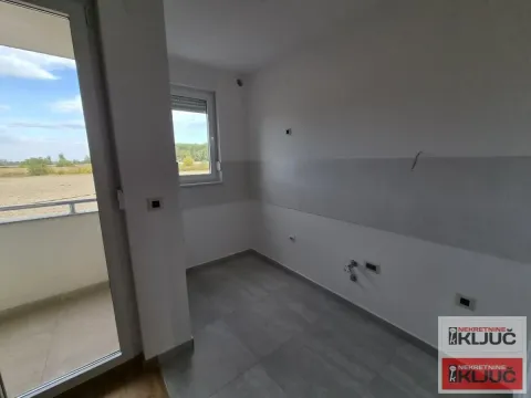Prazna prostorija sa izlazom na balkon i priključcima za kuhinju. - image 11