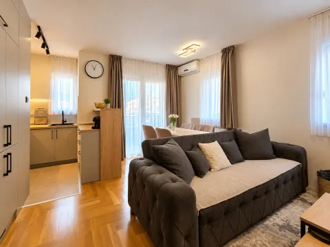 Living room with a sofa and a view towards the kitchen and dining area. - image 13