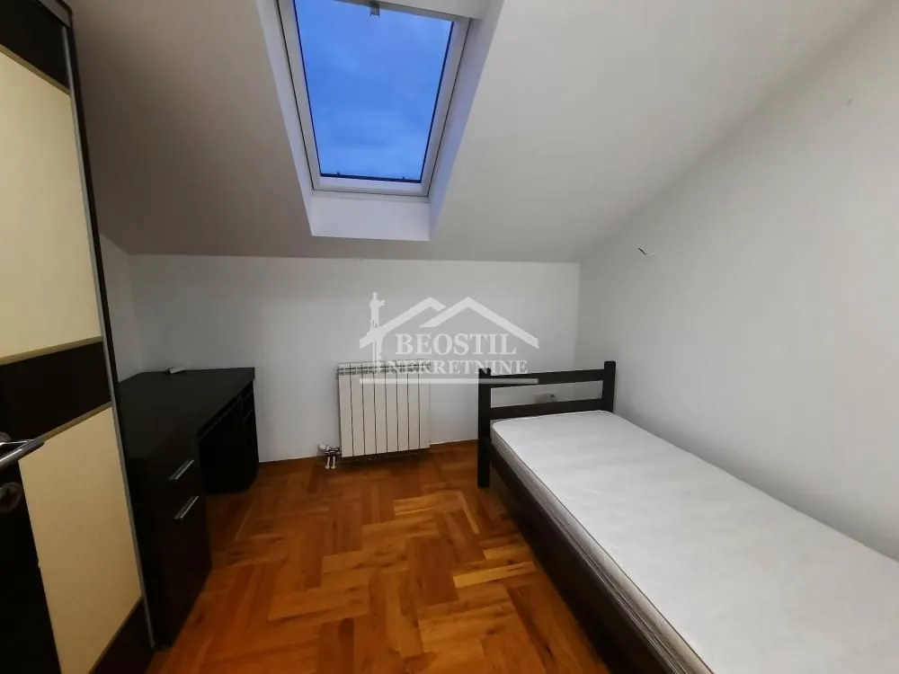 Smaller bedroom with a bed, desk, and roof window.