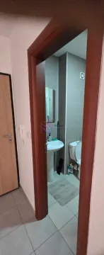 View through the doorway into the bathroom with a sink and toilet. - image 6