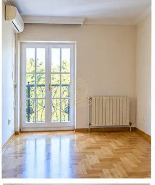 Empty room with hardwood floors, a radiator, and balcony doors. - image 3